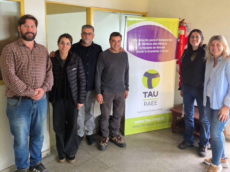 Equipo de Ideas Consultores, integrantes de la Cooperativa Tau y autoridades provinciales junto al banner de TAU RAEE